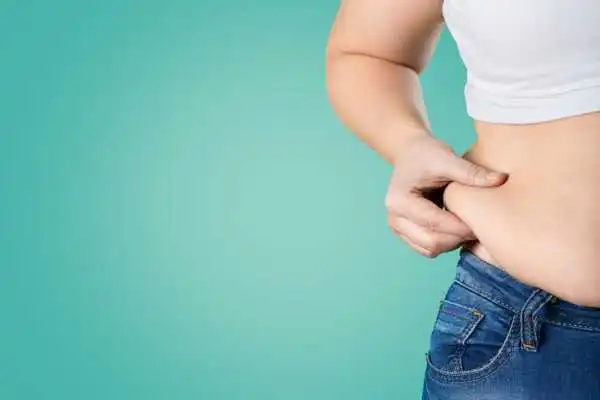 Image of woman pinching her love handles to show weight gain Preston